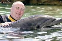 Alan Morris petting a dolphin at SeaWorld, Orlando.